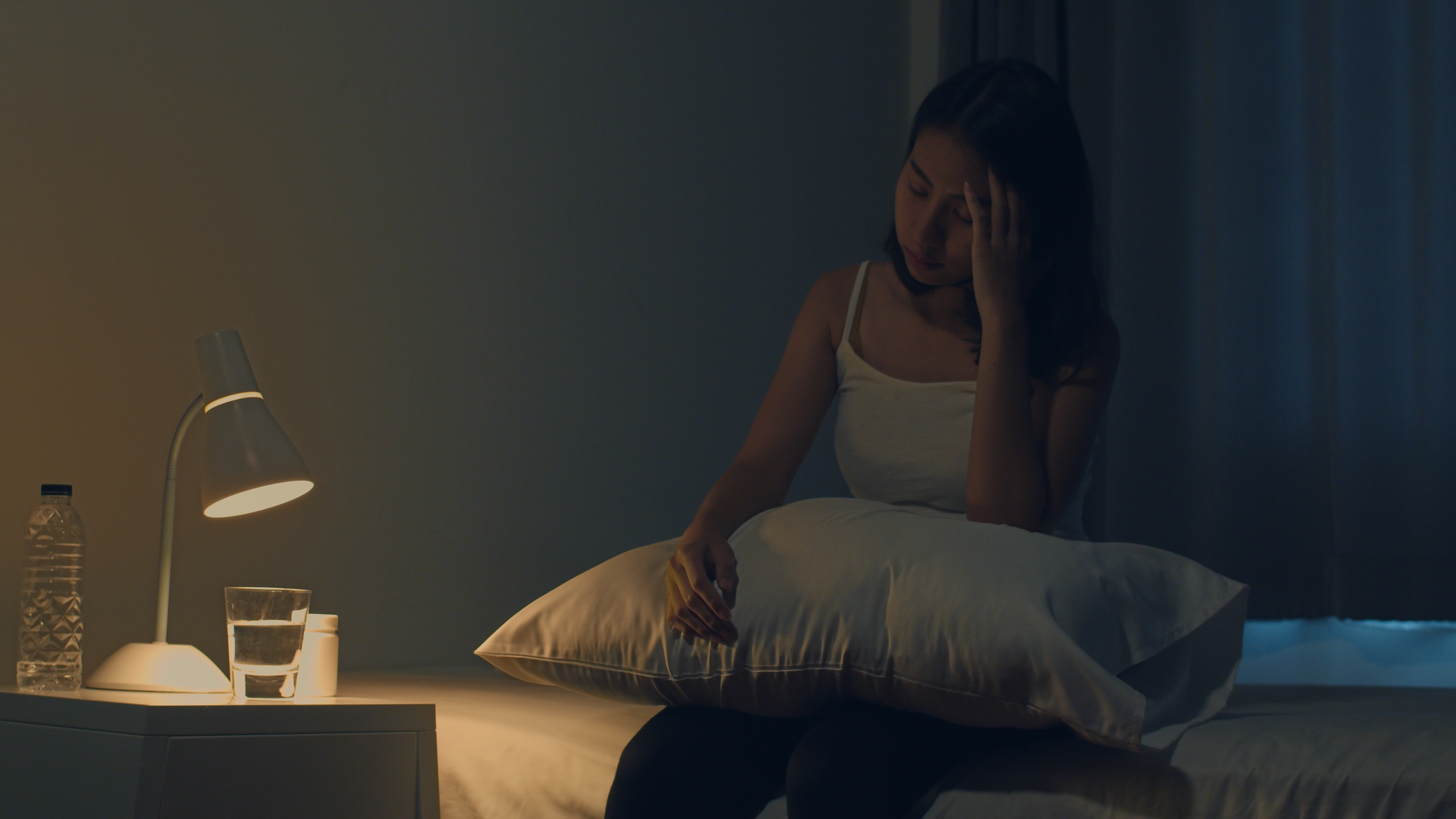 jovem-mulher-asiatica-bonita-que-senta-se-na-cama-toma-o-comprimido-para-dormir-ou-o-remedio-da-noite-no-quarto-mulher-indiana-doente-e-insalubre-sofre-de-insonia-ou-dor-de-cabeca-menina-deprimida-tem-remedios-ant.jpg